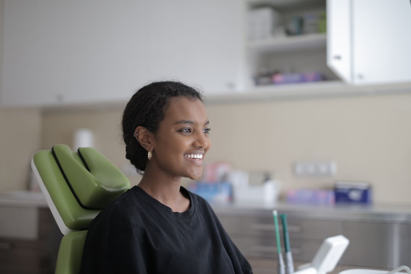 Woman smiling in a modern dental office before her aligner consultation
